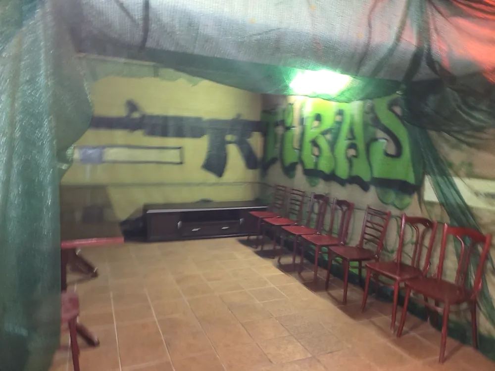 Patalpa su stalu ir kėdėmis šalia šaudymo linijos